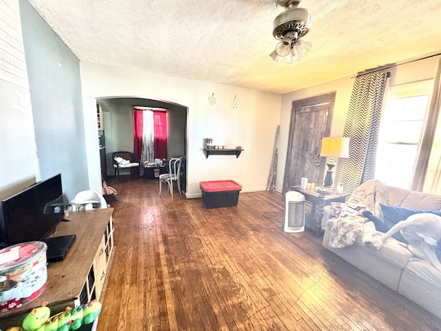 living room with a textured ceiling and dark wood-type flooring