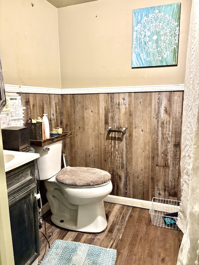 bathroom featuring vanity, wood-type flooring, and toilet