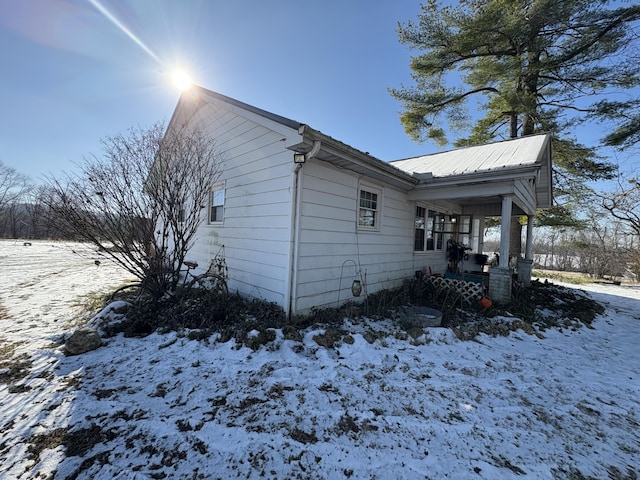 snow covered property with covered porch