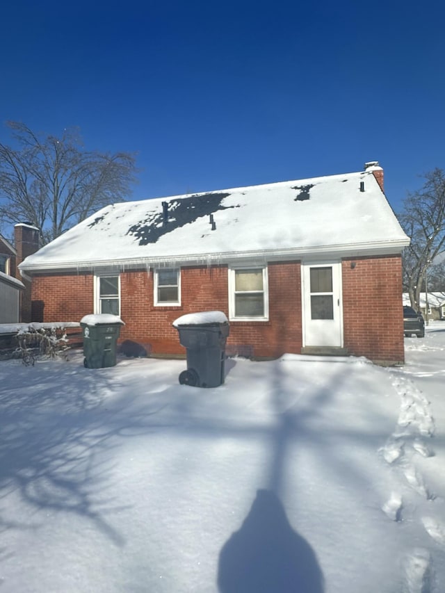 view of snow covered back of property