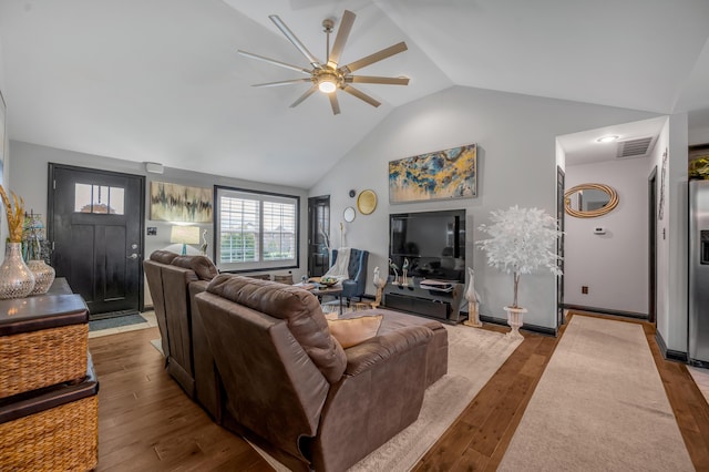 living room featuring ceiling fan, light wood-type flooring, and vaulted ceiling