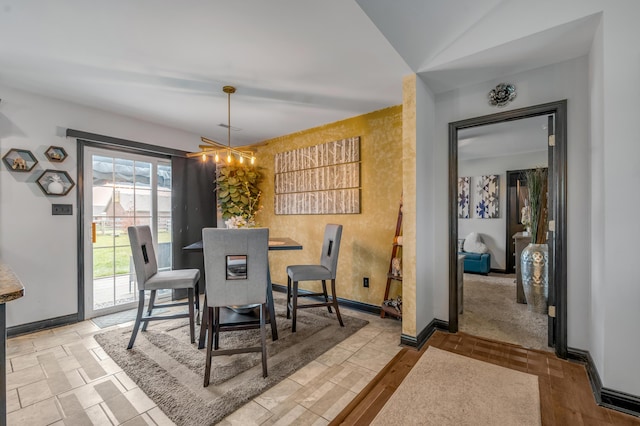 dining area featuring vaulted ceiling and an inviting chandelier