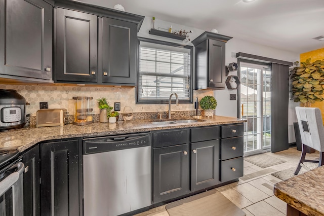 kitchen with stone counters, light tile patterned floors, sink, and appliances with stainless steel finishes