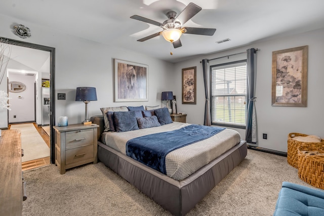 carpeted bedroom featuring ceiling fan and stainless steel fridge with ice dispenser