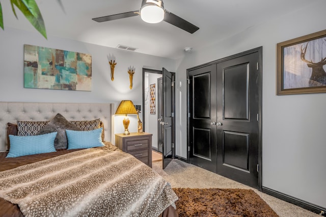 carpeted bedroom with ceiling fan and a closet