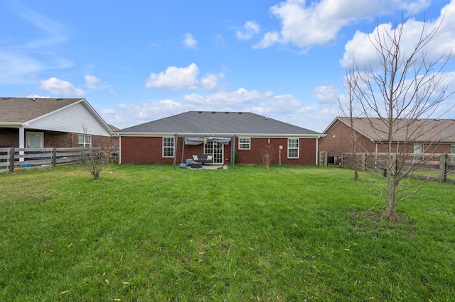 rear view of property featuring a lawn and a patio area