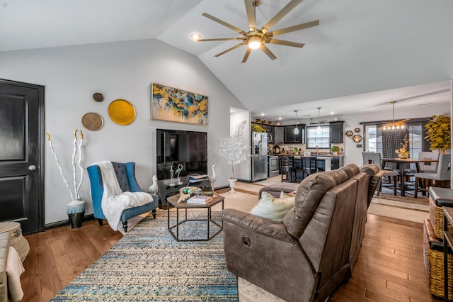 living room with light hardwood / wood-style floors, ceiling fan, and lofted ceiling