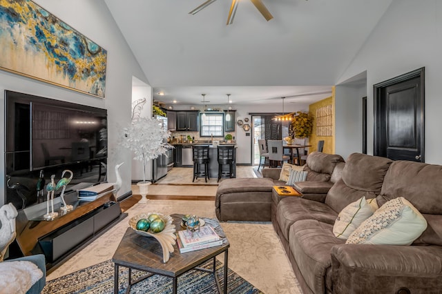 living room with ceiling fan with notable chandelier and vaulted ceiling