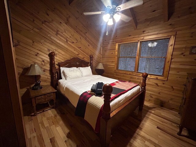 bedroom with wooden ceiling, light hardwood / wood-style floors, beam ceiling, and wood walls