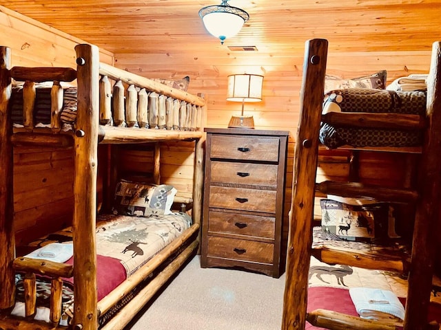 bedroom with carpet flooring, wooden walls, and wooden ceiling