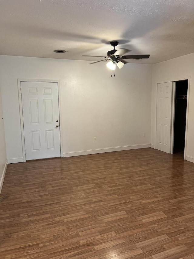 spare room featuring ceiling fan, dark wood-type flooring, and a textured ceiling