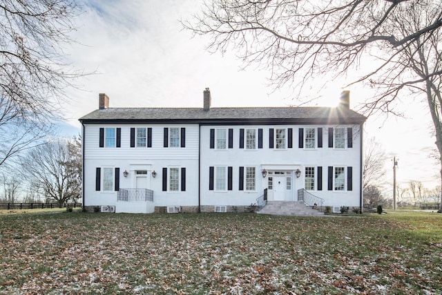 colonial inspired home featuring a front lawn