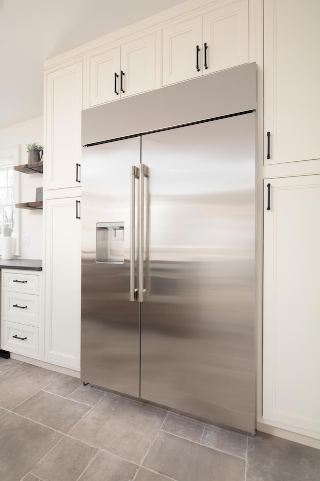 kitchen with built in fridge and white cabinets