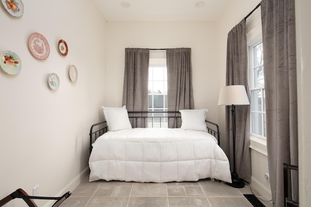 bedroom with light tile patterned floors and multiple windows