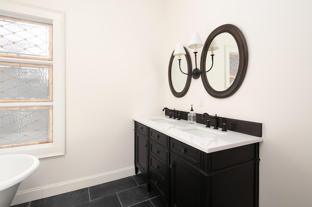 bathroom with a washtub, vanity, and tile patterned floors