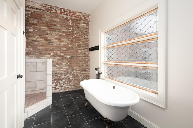 bathroom with a tub and brick wall