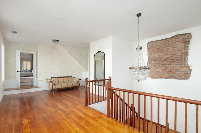 corridor featuring hardwood / wood-style flooring and a chandelier