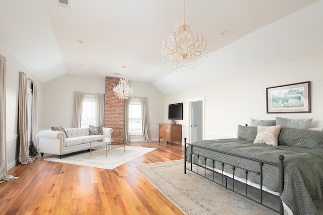 bedroom with hardwood / wood-style floors, a chandelier, and vaulted ceiling