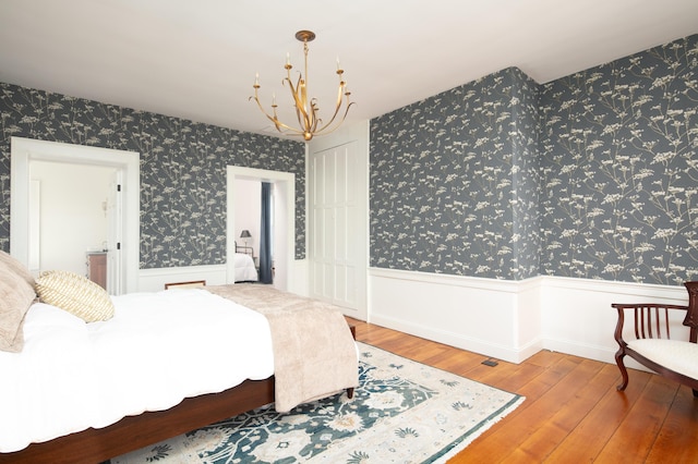 bedroom with hardwood / wood-style flooring and a chandelier