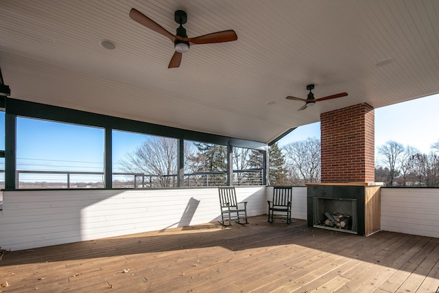 wooden terrace featuring an outdoor fireplace