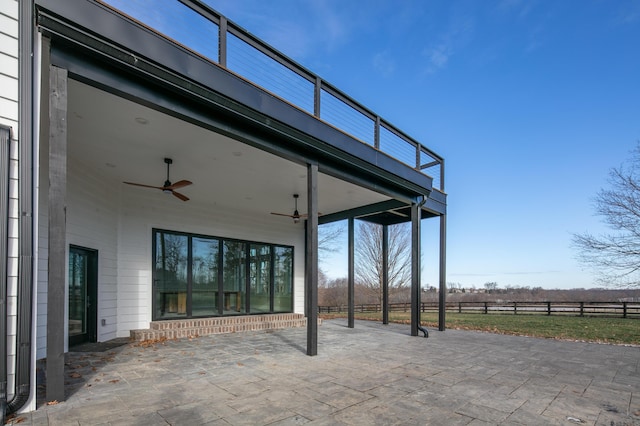 view of patio with ceiling fan and a balcony