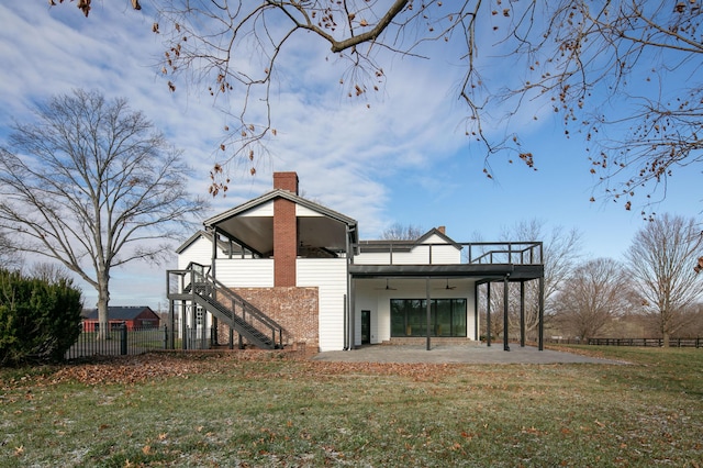 back of house with ceiling fan, a patio area, and a lawn