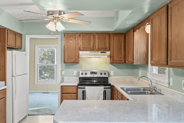 kitchen with white refrigerator, a wealth of natural light, sink, and stainless steel range with electric cooktop