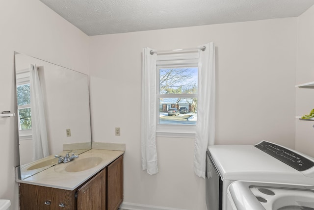 bathroom with vanity, a textured ceiling, and separate washer and dryer