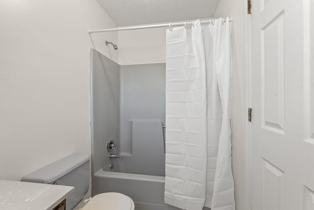 full bathroom featuring a textured ceiling, vanity, shower / bath combo with shower curtain, and toilet