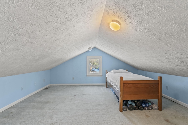 bedroom with a textured ceiling, lofted ceiling, and carpet floors