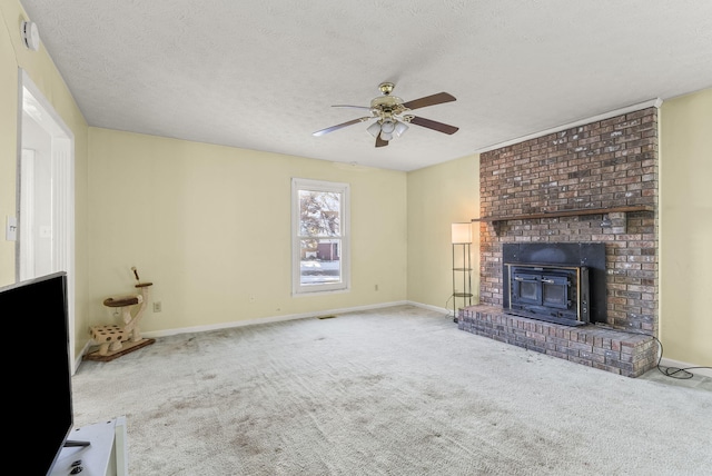 unfurnished living room with carpet flooring, a textured ceiling, ceiling fan, and a wood stove