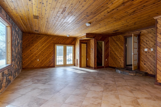 spare room featuring wood ceiling, french doors, and wooden walls