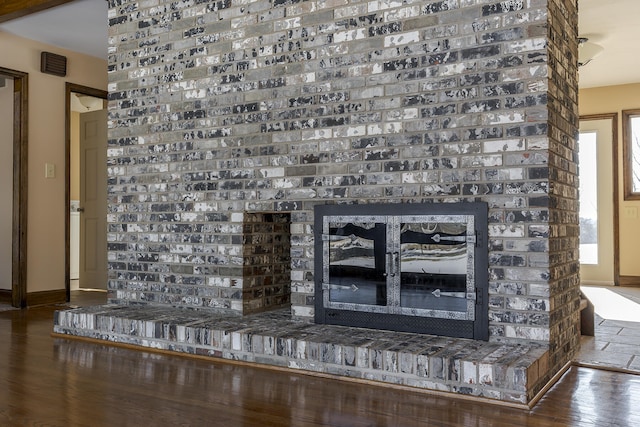 details featuring a brick fireplace and wood-type flooring