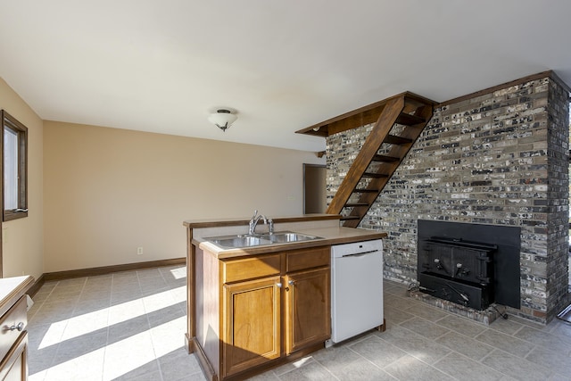 kitchen featuring a wood stove, dishwasher, and sink