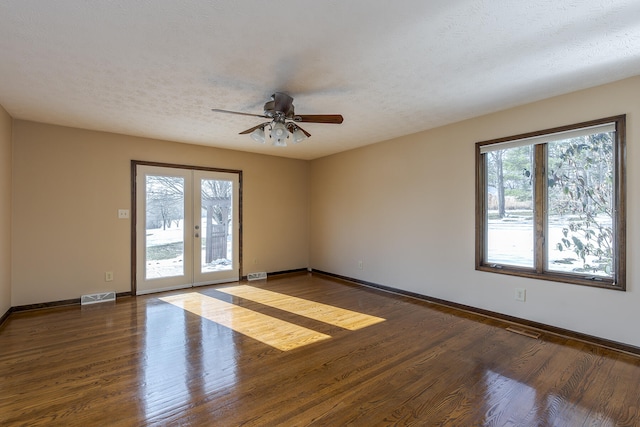 spare room with a textured ceiling, ceiling fan, french doors, and dark hardwood / wood-style floors