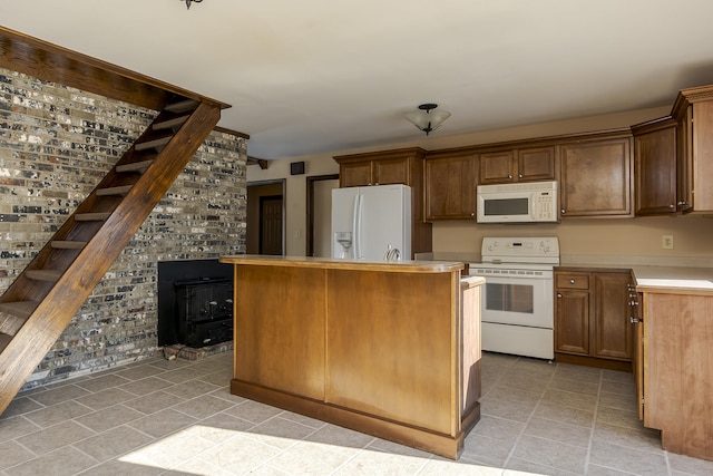 kitchen with brick wall, white appliances, a wood stove, and a kitchen island