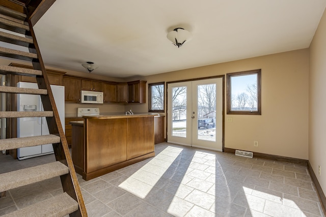 kitchen featuring kitchen peninsula, french doors, and range