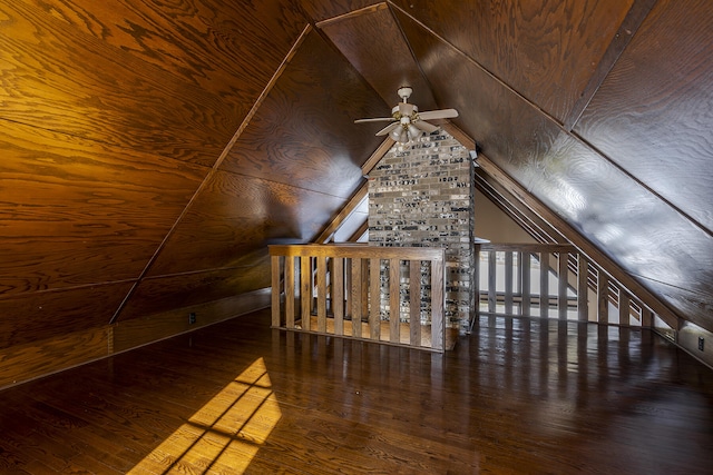 bonus room featuring lofted ceiling, wood ceiling, wooden walls, dark hardwood / wood-style floors, and ceiling fan