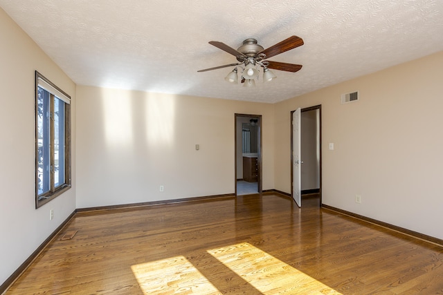 spare room with ceiling fan, wood-type flooring, and a textured ceiling