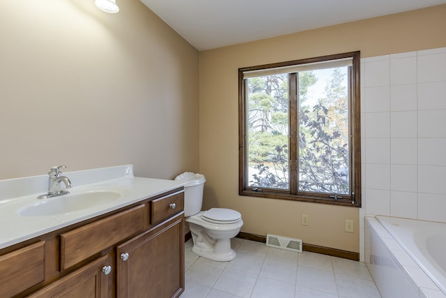 bathroom featuring vanity, toilet, tile patterned flooring, and a relaxing tiled tub