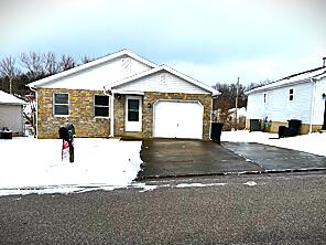 single story home featuring a garage and a front yard