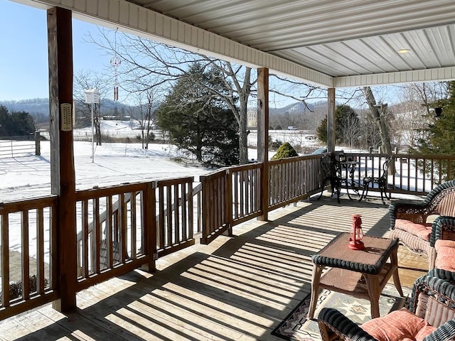 snow covered deck featuring a porch