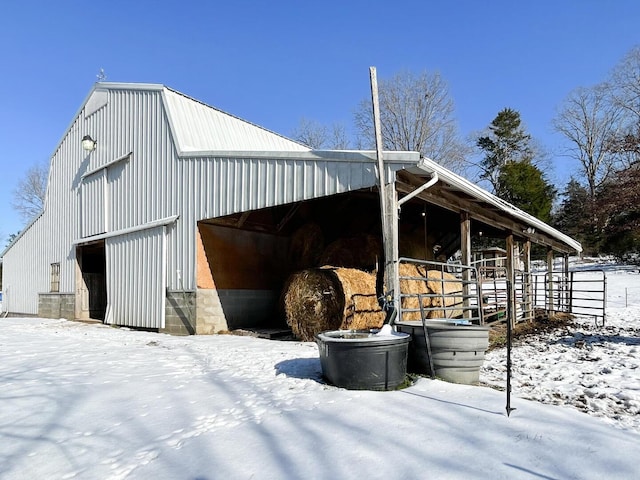 view of snowy exterior featuring an outbuilding