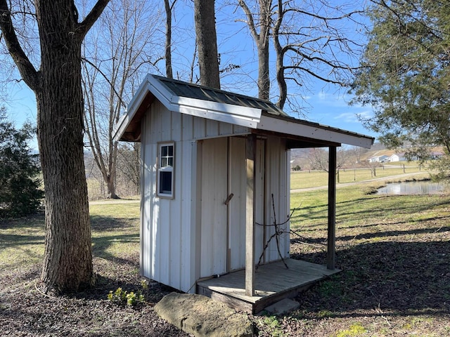 view of outbuilding featuring a water view and a yard