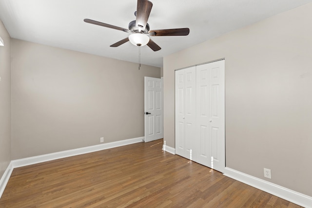 unfurnished bedroom with a closet, ceiling fan, and dark wood-type flooring