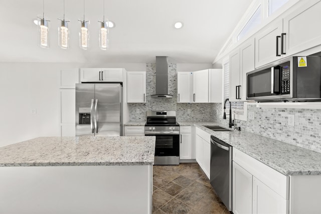 kitchen with white cabinetry, wall chimney exhaust hood, hanging light fixtures, stainless steel appliances, and vaulted ceiling