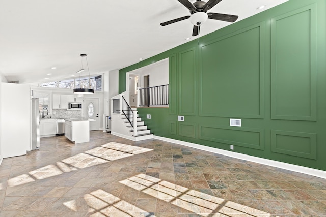 unfurnished living room with ceiling fan and lofted ceiling