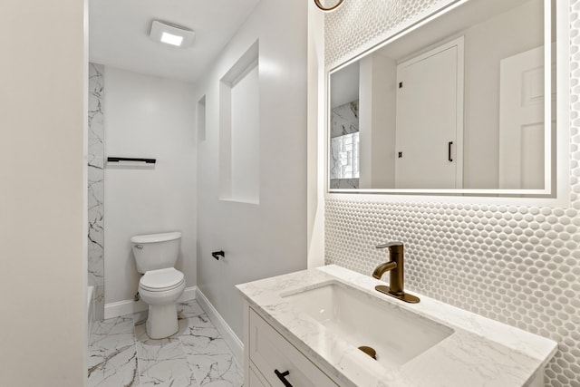 bathroom with vanity, toilet, and backsplash