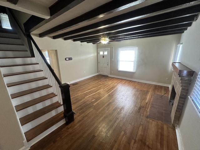 entrance foyer with ceiling fan, a fireplace, dark hardwood / wood-style floors, and beam ceiling