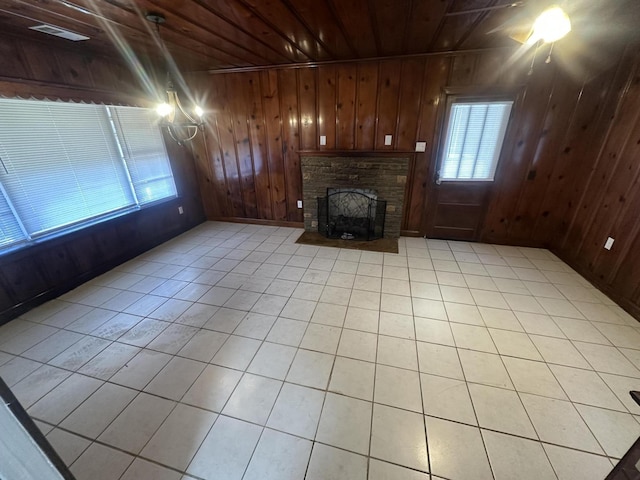 unfurnished living room with light tile patterned floors, wood ceiling, and wooden walls